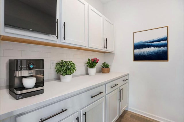 interior space with white cabinets, tasteful backsplash, and dark hardwood / wood-style floors