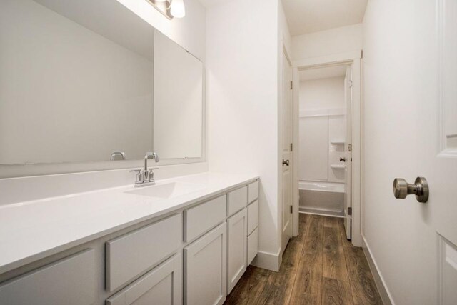 bathroom with wood-type flooring, vanity, and tub / shower combination