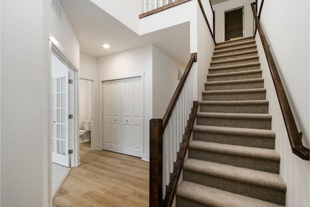 staircase featuring hardwood / wood-style flooring and a towering ceiling