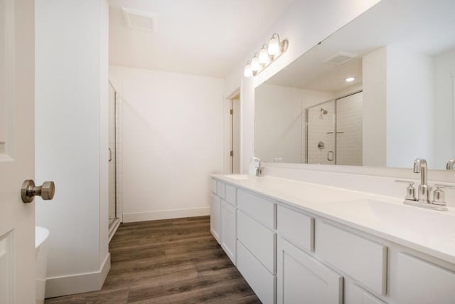 bathroom featuring hardwood / wood-style floors, vanity, and a shower with door