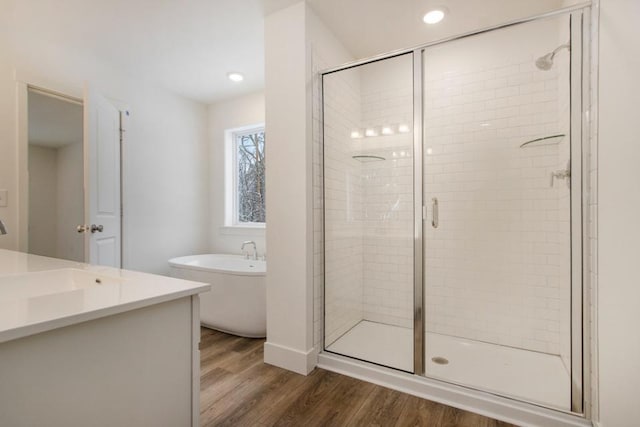 bathroom featuring hardwood / wood-style flooring, vanity, and shower with separate bathtub