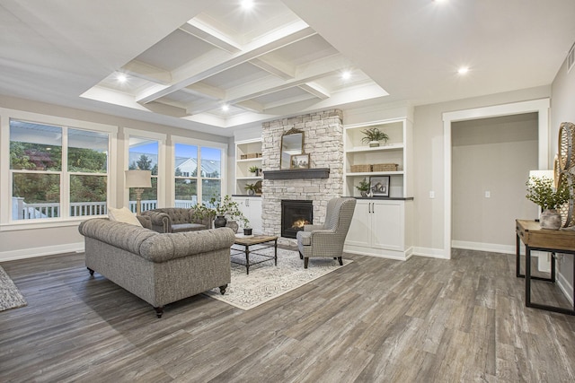 living room with beam ceiling, dark wood-type flooring, coffered ceiling, a stone fireplace, and built in features