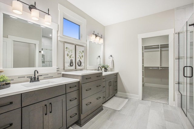 bathroom featuring decorative backsplash, vanity, and a shower with shower door