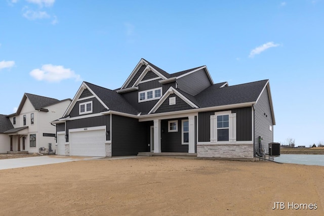 craftsman-style home featuring an attached garage, stone siding, driveway, and board and batten siding