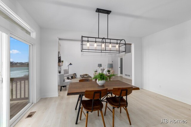 dining area with light wood-style floors and visible vents