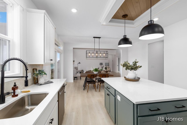 kitchen featuring a sink, white cabinetry, backsplash, dishwasher, and a raised ceiling