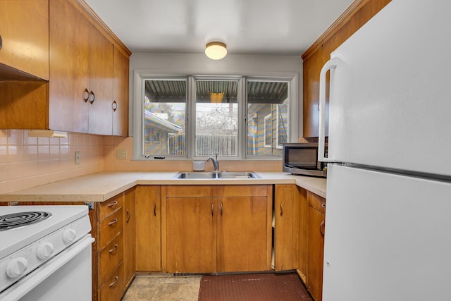 kitchen featuring white appliances, backsplash, and sink