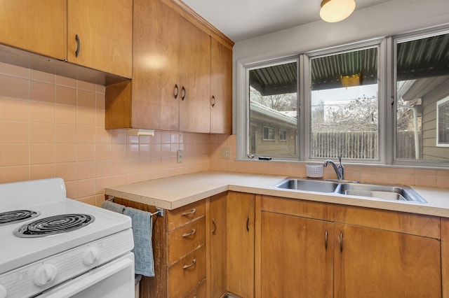 kitchen featuring white electric stove, decorative backsplash, and sink