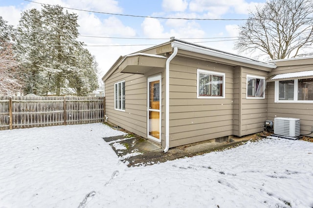 snow covered property featuring central AC unit