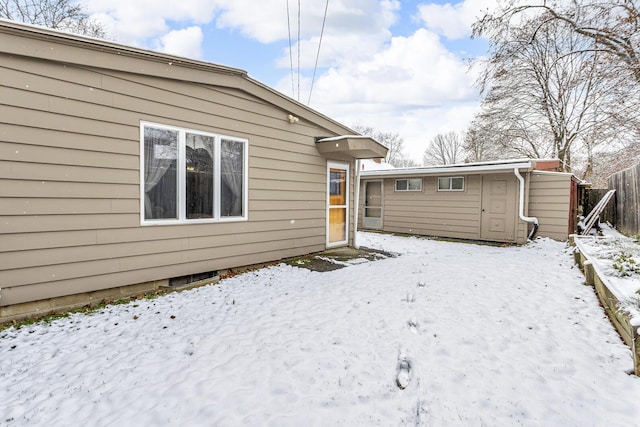 view of snow covered back of property