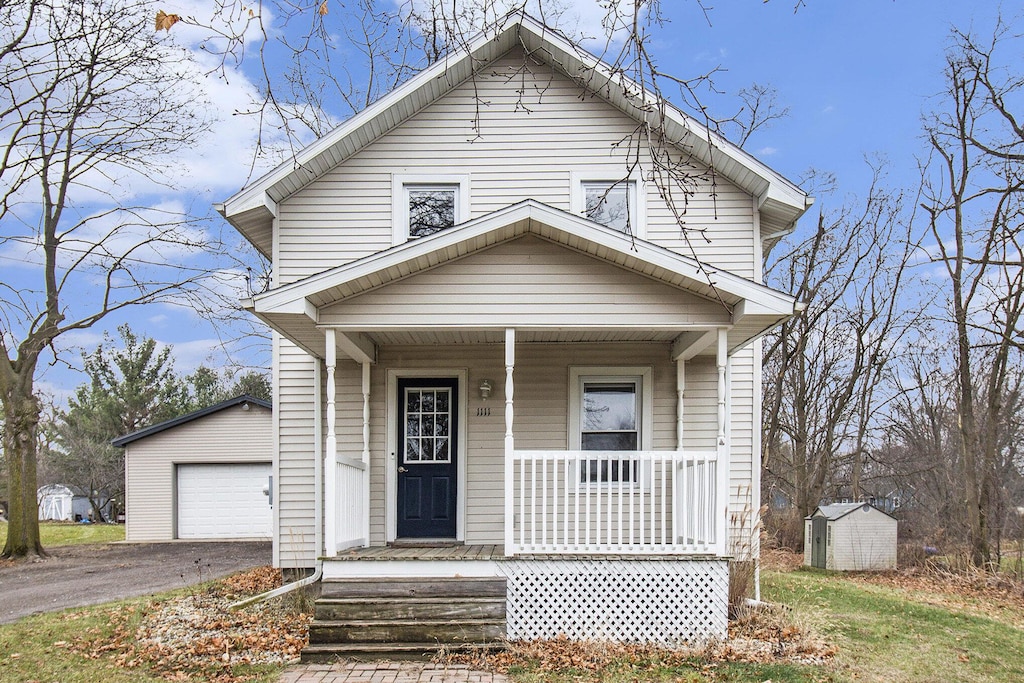 view of front of home with a garage and a storage shed