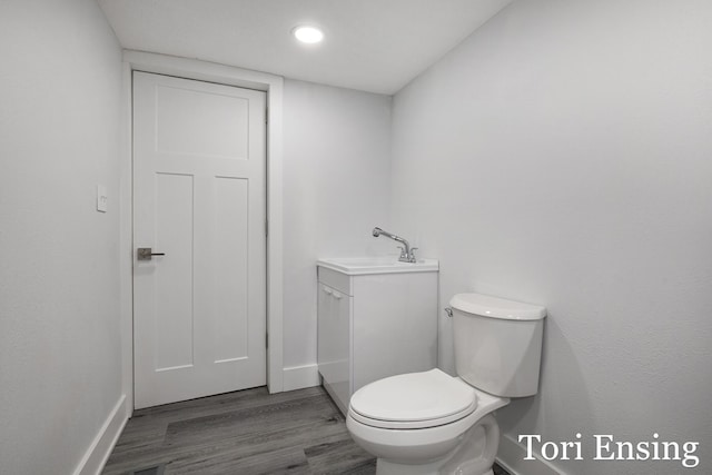 bathroom with hardwood / wood-style floors, vanity, and toilet