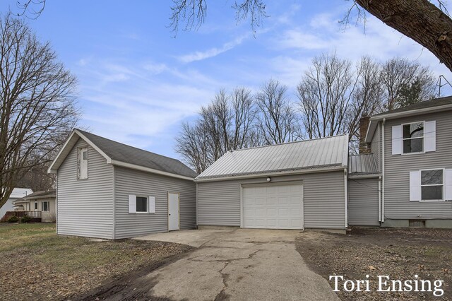 view of home's exterior with a garage and an outbuilding