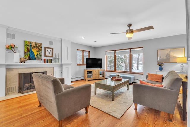 living room featuring light hardwood / wood-style floors, ceiling fan, and a baseboard radiator