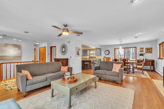 living room featuring ceiling fan and light hardwood / wood-style floors