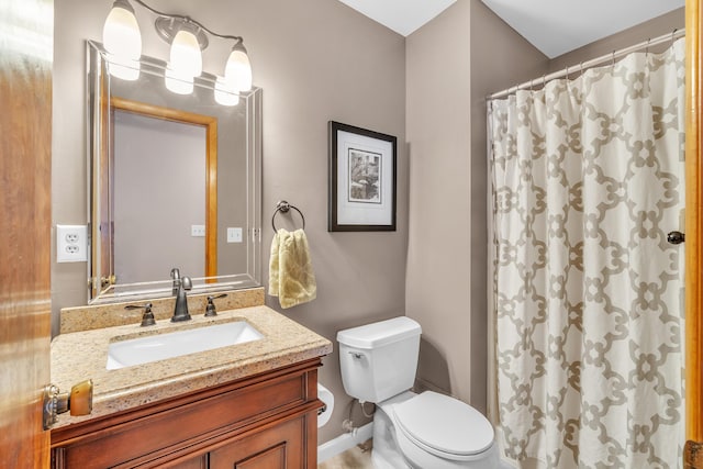 bathroom featuring curtained shower, vanity, and toilet