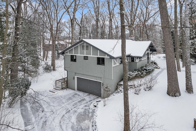 view of snowy exterior with a garage