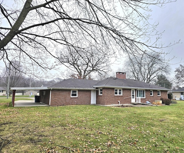 rear view of property featuring a carport and a lawn