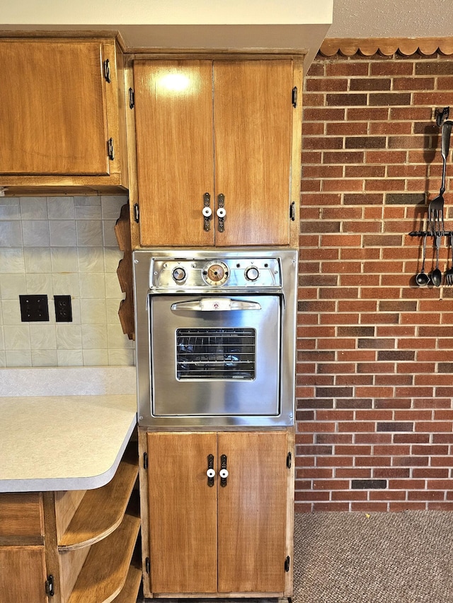 kitchen featuring stainless steel oven and backsplash