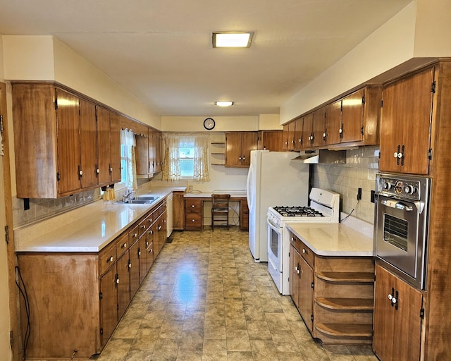 kitchen with tasteful backsplash, stainless steel oven, white range with gas stovetop, and sink