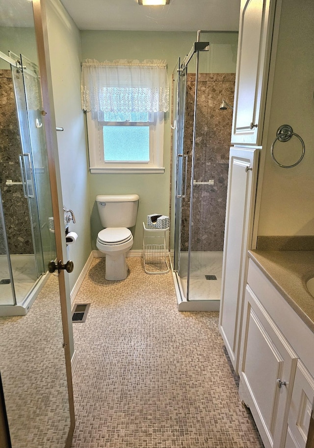 bathroom featuring vanity, an enclosed shower, and toilet