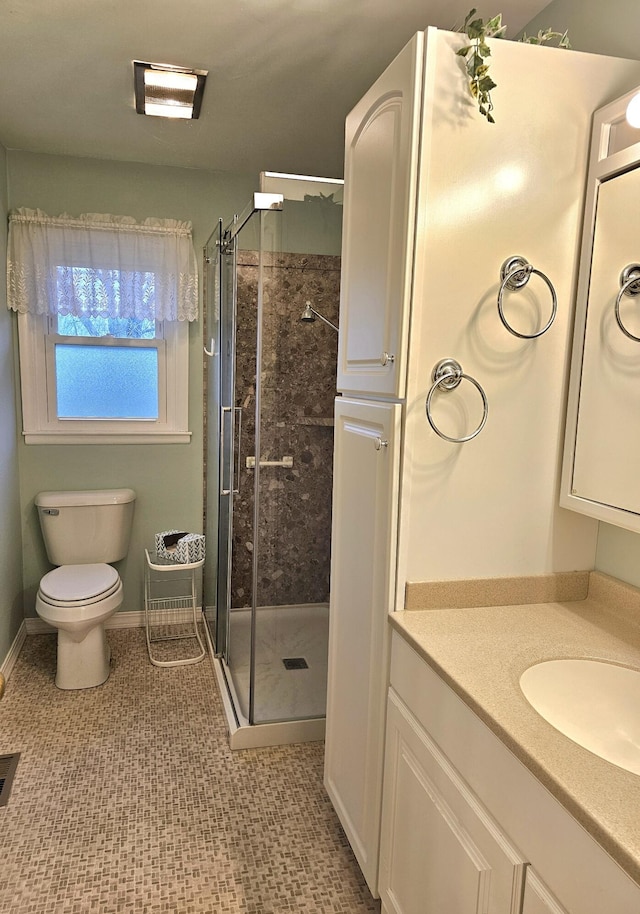 bathroom with tile patterned flooring, vanity, toilet, and a shower with shower door