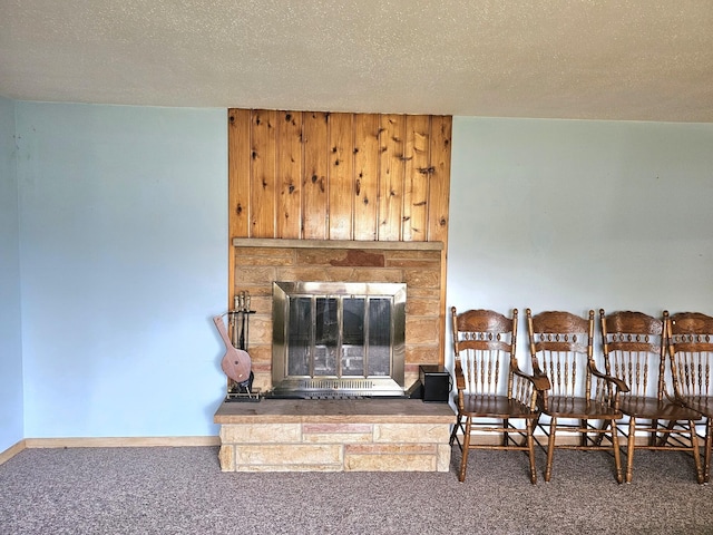 living room with carpet, a textured ceiling, and a fireplace