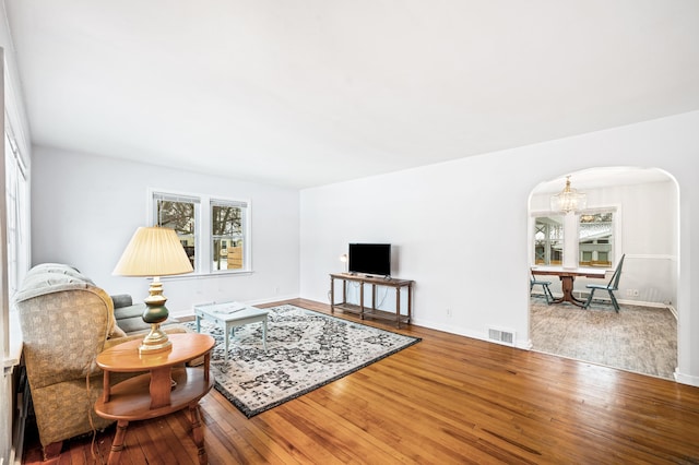 living room with hardwood / wood-style flooring and a notable chandelier