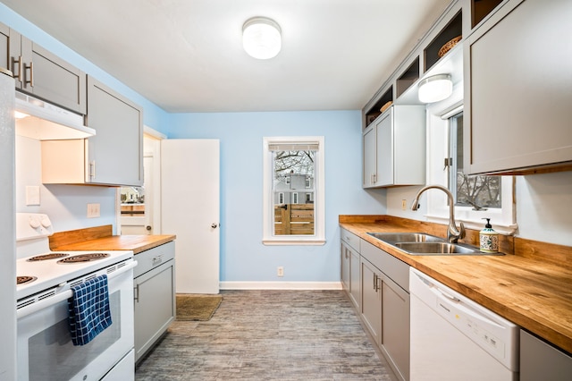 kitchen with wooden counters, white appliances, gray cabinetry, and sink