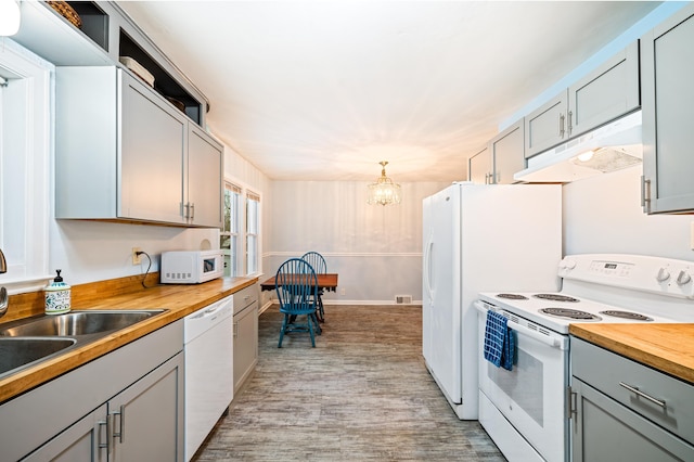 kitchen featuring gray cabinetry, white appliances, an inviting chandelier, light hardwood / wood-style floors, and butcher block counters