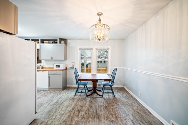 dining room with hardwood / wood-style flooring and a notable chandelier