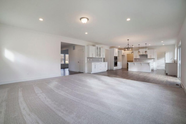 unfurnished living room featuring sink