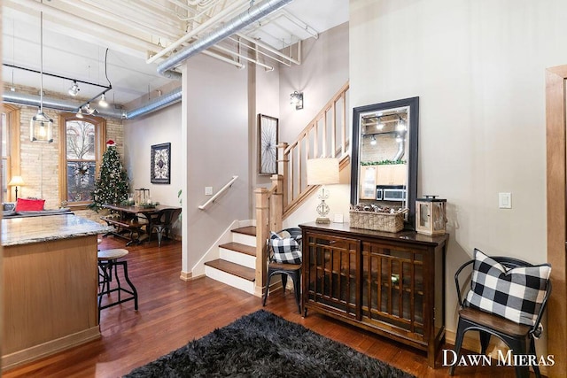 interior space with hardwood / wood-style floors, rail lighting, and a high ceiling