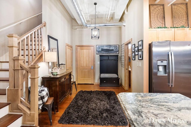 foyer entrance featuring a towering ceiling and hardwood / wood-style flooring