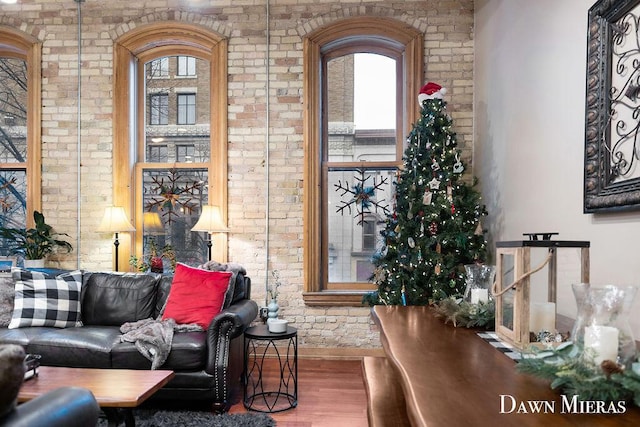 living room featuring hardwood / wood-style floors and brick wall