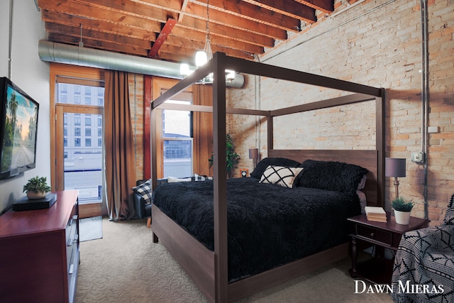 carpeted bedroom featuring brick wall