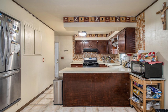 kitchen featuring sink, light tile patterned floors, appliances with stainless steel finishes, dark brown cabinets, and kitchen peninsula