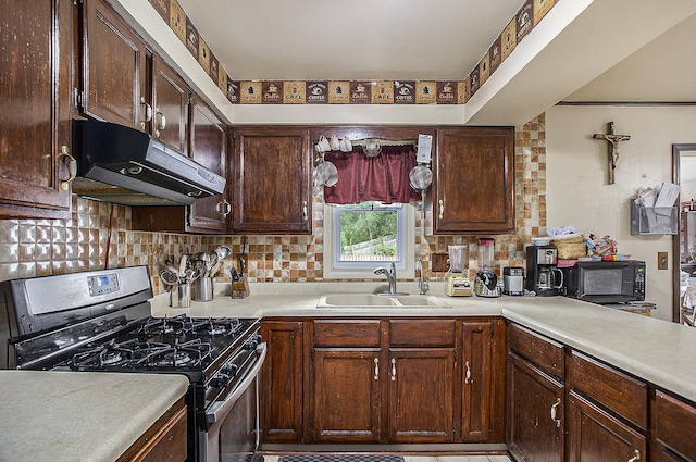 kitchen with black range with gas stovetop, dark brown cabinetry, sink, and tasteful backsplash