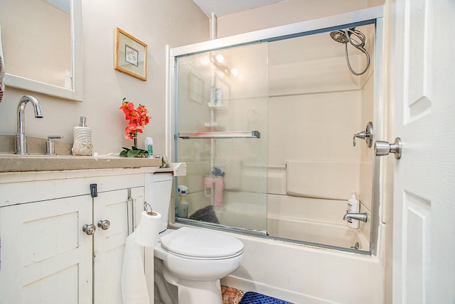 full bathroom with combined bath / shower with glass door, vanity, and toilet