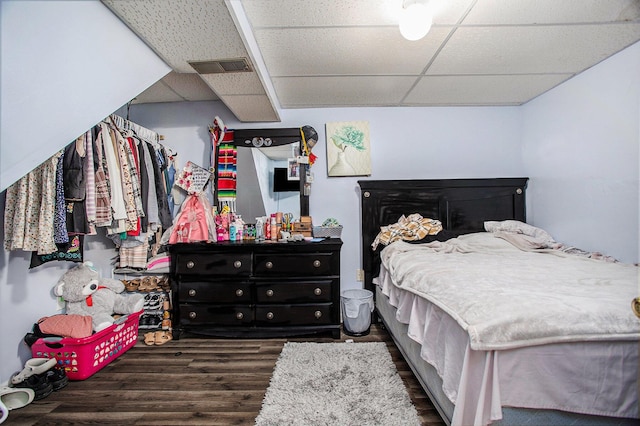 bedroom featuring dark hardwood / wood-style floors and a drop ceiling