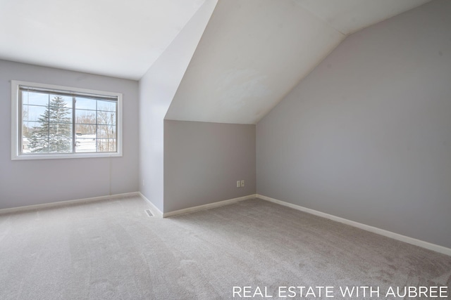 bonus room featuring light carpet and vaulted ceiling