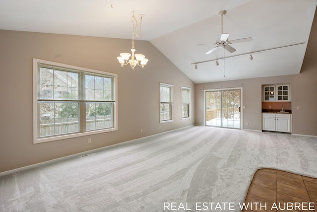 unfurnished living room with carpet, sink, vaulted ceiling, and a wealth of natural light