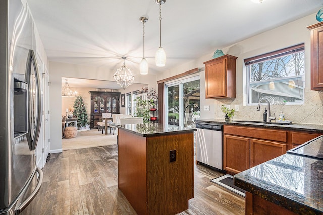 kitchen featuring plenty of natural light, a kitchen island, sink, and appliances with stainless steel finishes