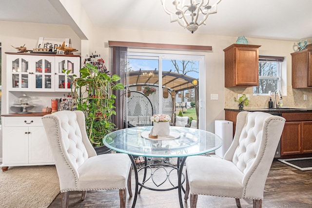 dining area with sink, a chandelier, and dark hardwood / wood-style floors