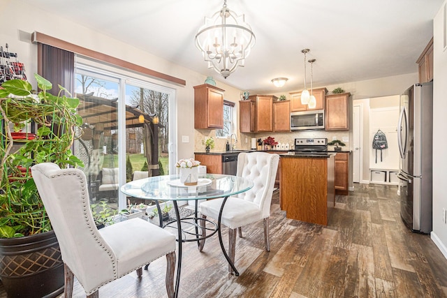 dining room featuring a notable chandelier, plenty of natural light, and dark hardwood / wood-style floors