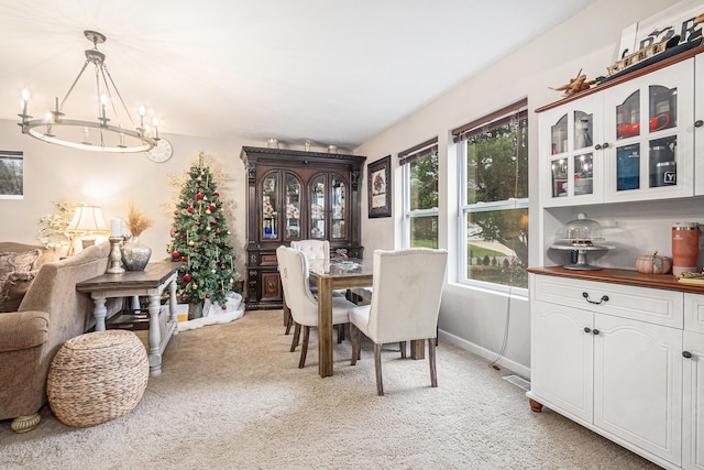 carpeted dining space featuring an inviting chandelier