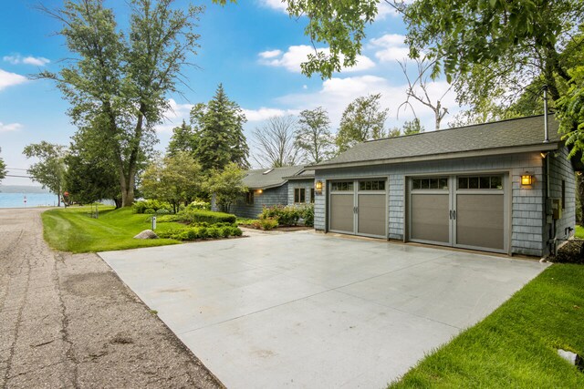 garage with a water view and a yard