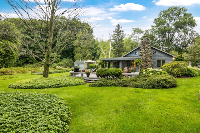 rear view of property with a deck and a yard