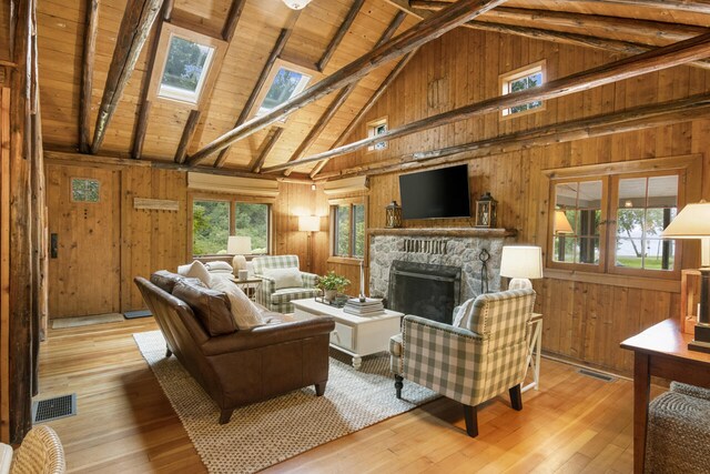 living room featuring light hardwood / wood-style floors, a wealth of natural light, and wood walls