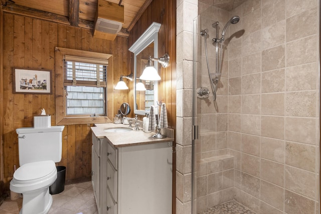 bathroom featuring vanity, tile patterned floors, wooden walls, toilet, and walk in shower